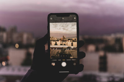 Close-up of hand holding smart phone in city