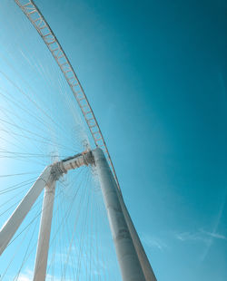 Low angle view of ferris wheel against blue sky