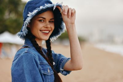 Portrait of young woman standing at beach