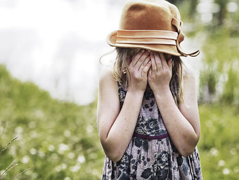 Girl with hands covering face