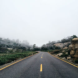 Empty road passing through country road