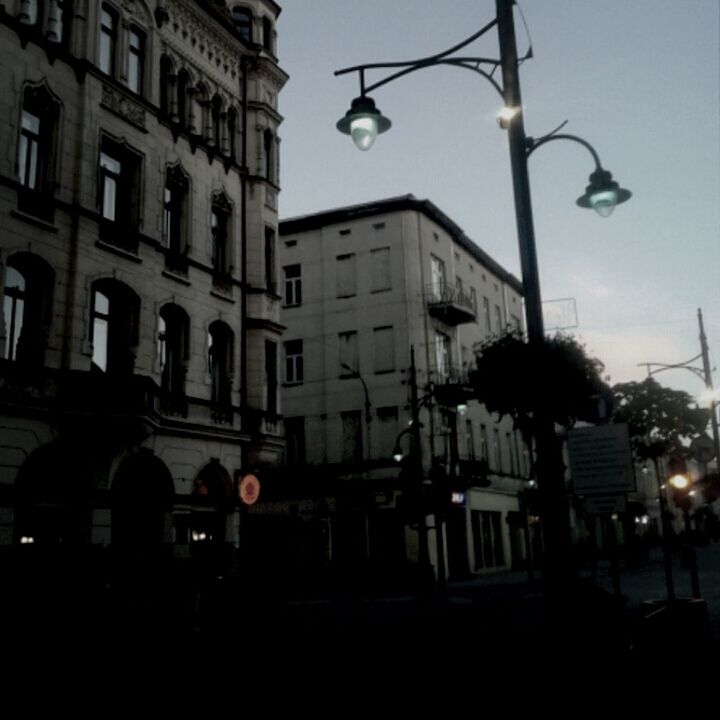 architecture, building exterior, built structure, street light, lighting equipment, sky, low angle view, illuminated, city, window, clear sky, building, dusk, silhouette, incidental people, outdoors, electric light, night, lamp post, in a row