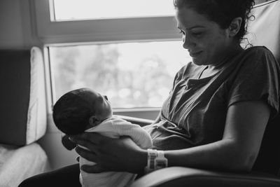 Woman holding newborn son in hospital