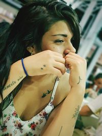 Tattooed young woman looking away in cafe