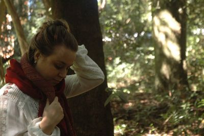 Young woman standing at forest