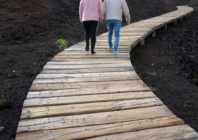 Low section of couple walking on footpath