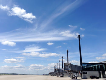 Cars on road against cloudy sky