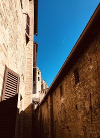 Low angle view of buildings against clear blue sky