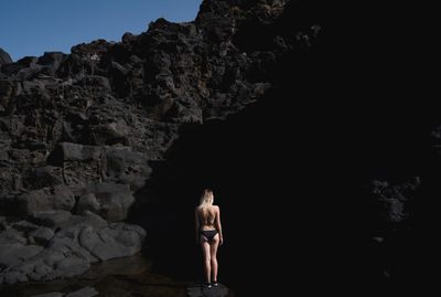 Woman standing on rock formation in cave