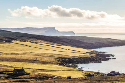Scenic view of sea and mountains against sky