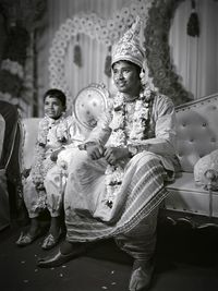 Full length of a smiling girl sitting outdoors