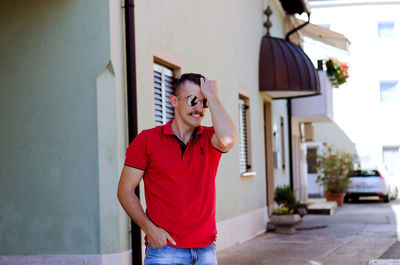 Young happy handsome bearded man, tourist walking in old city of koper. summer vacation. sunglasses