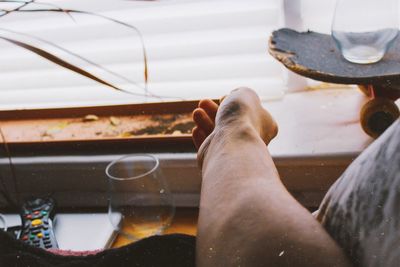 Low section of man with reflection in glass