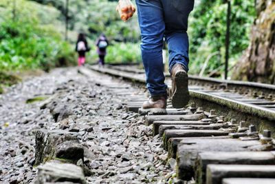 Low section of man standing on railroad track