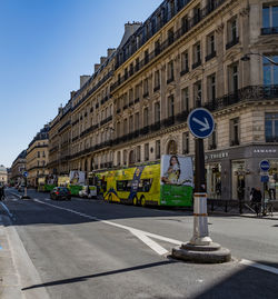 Cars on road against sky in city