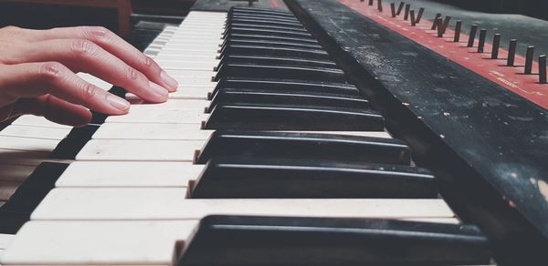 Cropped image of person playing piano