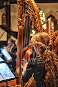 Rear view of woman playing piano