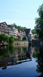 River by buildings against sky