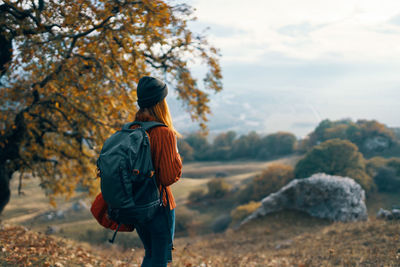 Rear view of woman standing on rock