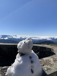 Snow covered mountain against blue sky