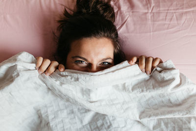 Portrait of young woman sitting on bed