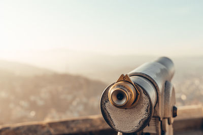 Close-up of coin-operated binoculars against sky