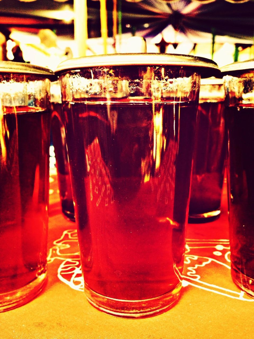 indoors, drink, restaurant, table, food and drink, incidental people, person, drinking glass, red, glass - material, refreshment, chair, illuminated, men, lifestyles, in a row, alcohol, large group of people, close-up