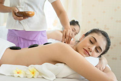 Young woman receiving lastone therapy in spa