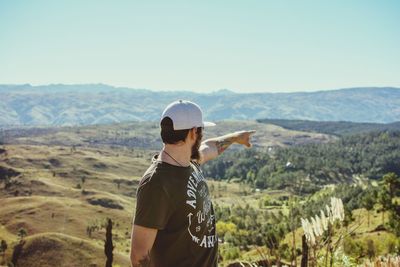 Rear view of man standing on mountain landscape