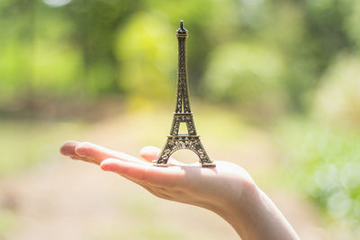 Close-up of hand holding model eiffel tower