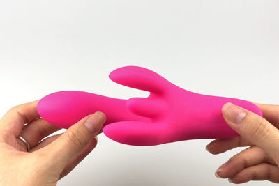 Close-up of hand holding hands over white background