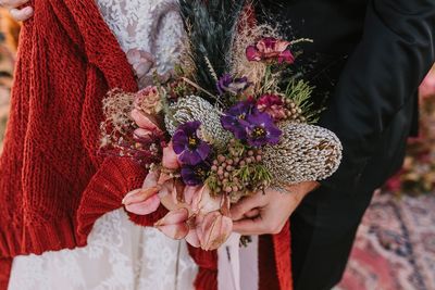Midsection of woman holding flowering plant