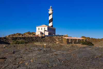 The far de favaritx lighthouse, painted black and white in a spiral, menorca island, baleares, spain