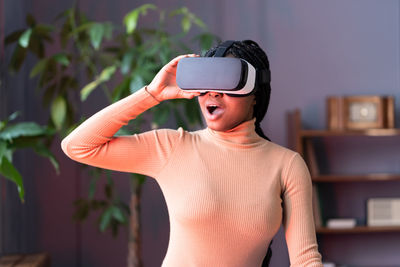 Afro woman feel shocked watching movie in vr glasses surprised with effect of presence in simulation