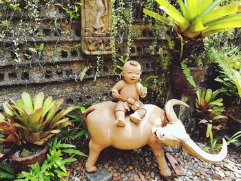 Statue of buddha against plants