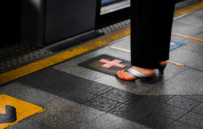 Low section of woman standing on tiled floor