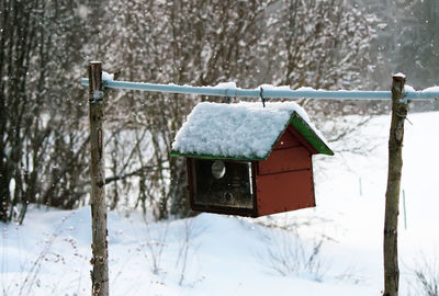 Birdhouse hanging on wooden sticks. 