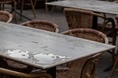 Empty table and empty chairs of summer restaurant or beer garden in summer on rainy day raindrops