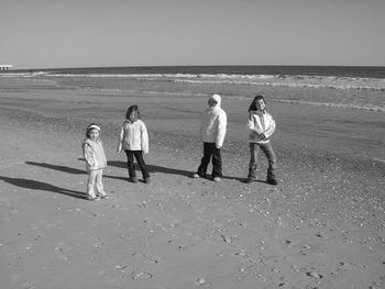 People on beach against clear sky