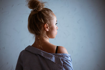 Portrait of a woman against the background of a gray wall