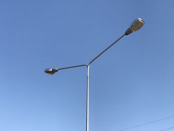 Low angle view of street light against blue sky