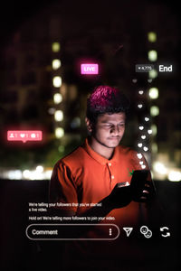 Young man using mobile phone at night