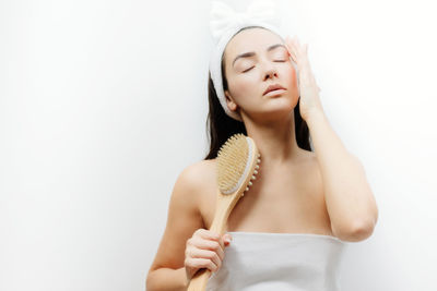 Beautiful woman with eyes closed against white background