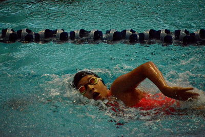 Portrait of shirtless man lying in swimming pool