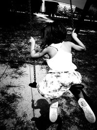 Rear view of girl playing in mid-air