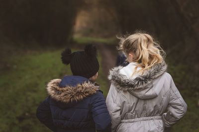 Rear view of 2 children walking outdoors