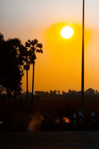 Silhouette trees against orange sky during sunset