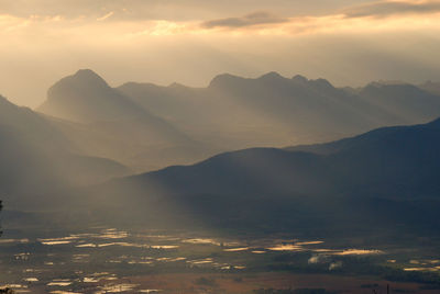 Scenic view of mountains against sky at sunset