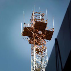 Low angle view of communications tower against clear blue sky