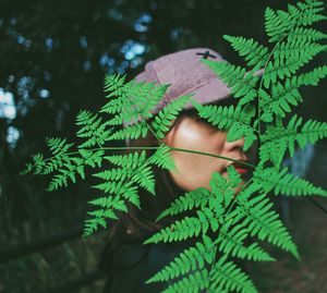 Close-up of woman seen through plants